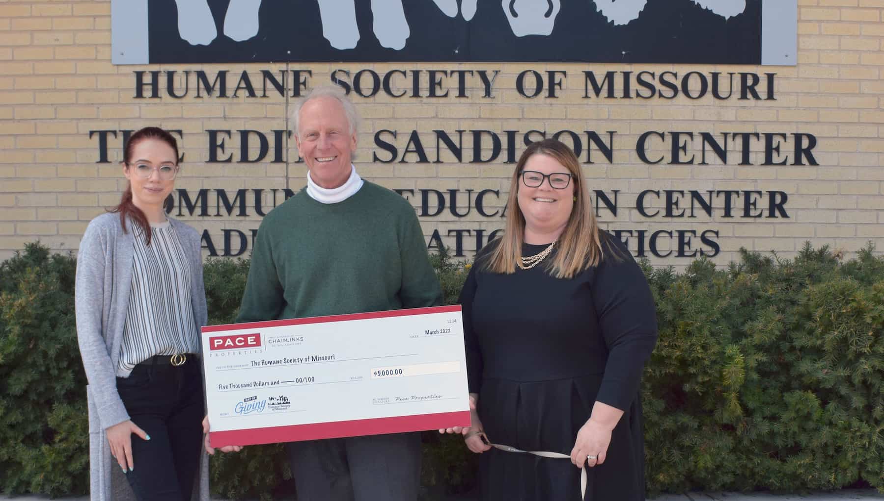 Pace and Humane Society representatives smiling with large donation check