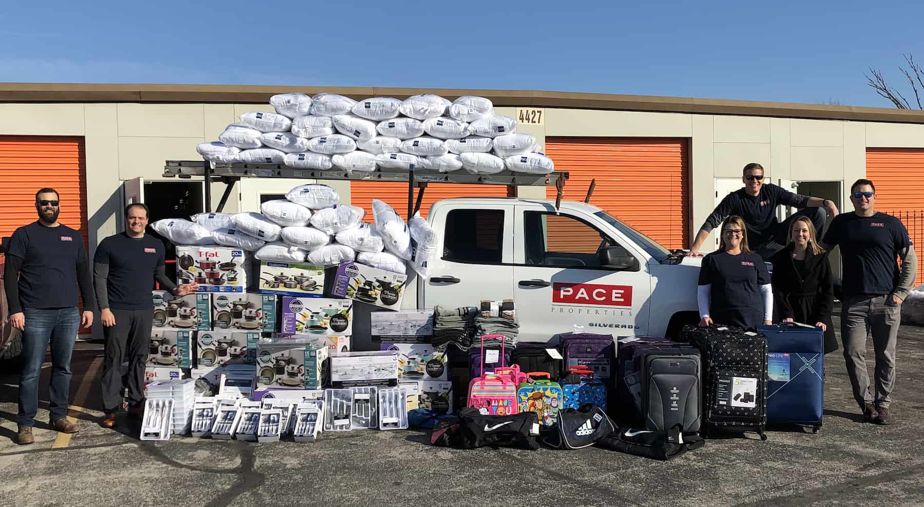 Pace team standing with supplies being donated to Fostering Futures